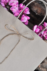 disposable paper craft eco bag with pink acacia flowers, zero waste concept