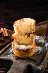 Traditional portuguese egg tart on wooden cutting board