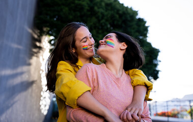 lesbian girls having fun painting themselves and with the lgtb flag on pride day
lgtb concept