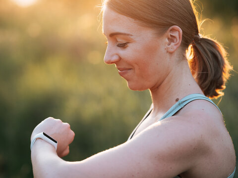 Woman using fittness watch to measure workout. Analyze helath data using smart watch.