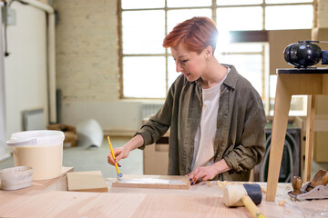 wood crafts, woman artisan carpenter painting with brush the piece of wooden board in workshop, dressed casually, interior designer, restoration, diy and handmade works concept