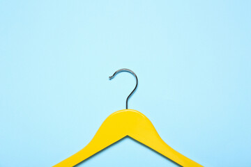 Stylish clothes hanger on color background