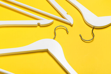 Stylish clothes hangers on color background, closeup