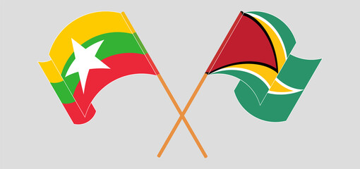 Crossed and waving flags of Myanmar and Guyana