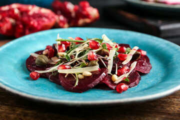 Plate with delicious beetroot carpaccio on dark wooden table, closeup