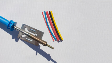 Naklejka premium Electric soldering iron with blue handle on white background