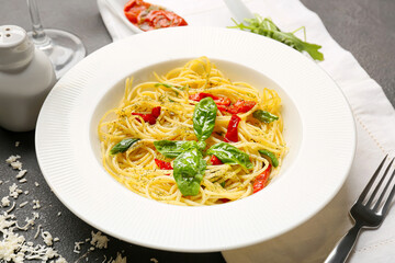 Plate with tasty pasta and cheese on dark background