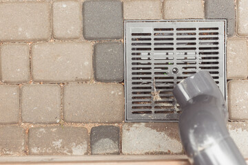 stormwater pipe on facade with rainwater drainage into the drainage system with a sewer manhole...