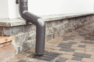 stormwater pipe on facade with rainwater drainage into the drainage system with a sewer manhole...