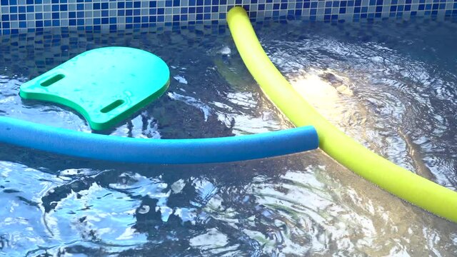 Swim noodles and pool board for teaching kids in swimming pool, aqua aerobics.