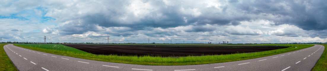 panorama of agricultural fields on the other side of a small dike with a fisheye effect