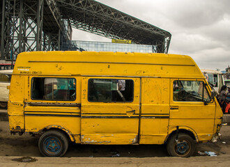 Lagos yellow bus on the road - Danfo parked by the roadside in Oshodi - obrazy, fototapety, plakaty