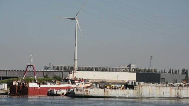 Silo`s and windmill with heaps of coal and ore in front in the in the harbour of Ghent, flanders, belgium 