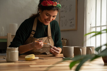 Ceramist young woman Making Clay cups  in her studio