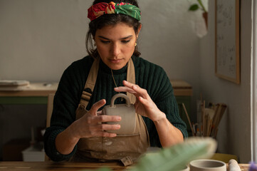 Ceramist young woman Making Clay cups  in her studio