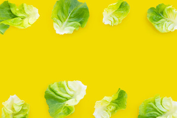 Lettuce leaves on yellow background. Copy space