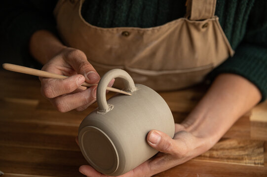 Close up of ceramist woman Making Clay cups  in her studio - Powered by Adobe