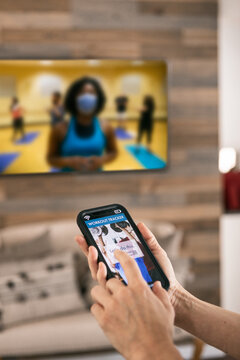 Home: Woman Uses Phone App During Streaming Workout Class