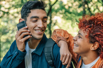 Fototapeta premium young multicultural couple with mobile phone on the road