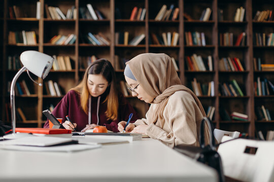 Focused female students working on project in library