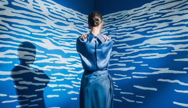 Stylish fashion female model in front of the abstract white and blue space.