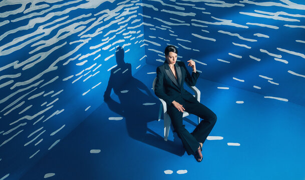 Stylish Fashion Female Model In Front Of The Abstract White And Blue Space.