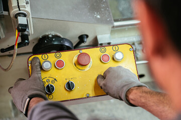 Male worker using controller and operating industrial machine