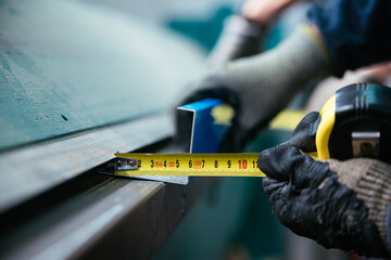 Crop worker using measuring tape at factory