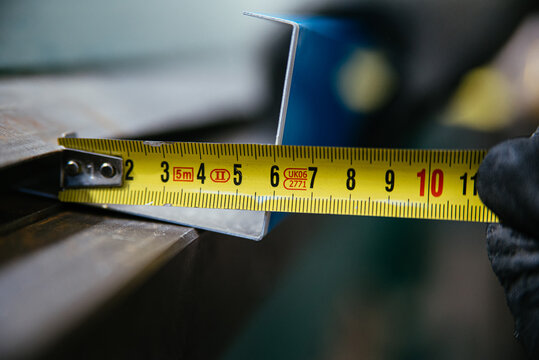 Crop worker using measuring tape at factory