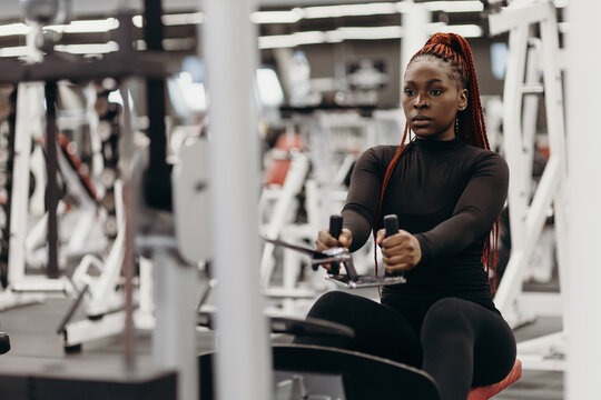 African American girl doing exercises on rowing machine