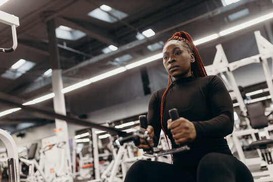 African american woman doing exercises on rowing machine