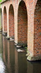 Aqueduct pillars reflecting in the water surface. The town of Nieborow near Lodz.
