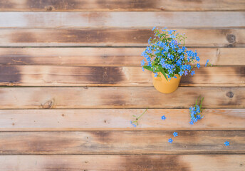 Flowers in a vase. Blue flowers. Forget-me-nots flowers. Forget-me-nots flowers on wooden table. Bouquet of Forget-me-nots flowers. Vintage floral background with Forget-me-not. Copy space