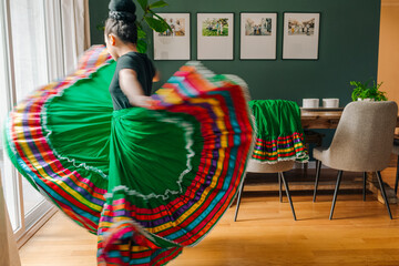 Tween girl trying on her traditional Mexican folkloric skirt at home