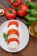 Tasty italian vegetarian food, fresh soft white mozzarella cheese served with red tomatoes and green basil