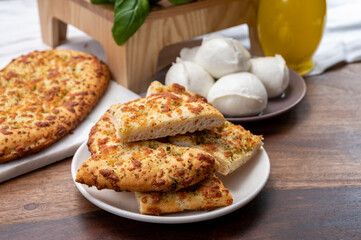 Tasty italian vegetarian food, fresh baked flat foccachia bread with white mozzarella cheese and herbs