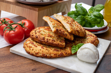 Tasty italian vegetarian food, fresh baked flat foccachia bread with white mozzarella cheese and herbs