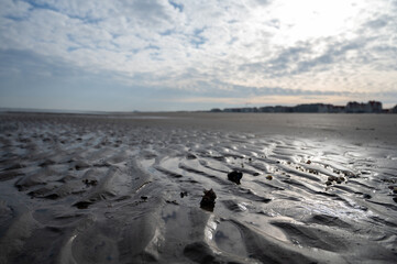 Low tide period on yellow sandy beach in small Belgian town De Haan or Le Coq sur mer, luxury vacation destination, summer holidays