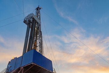Drilling rig for drilling wells for oil and gas. General detailed view. View from the side from bottom to top.  Drill tower on the base and drill pipes for lowering into the well