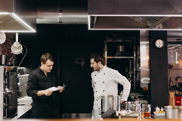 Cooks discussing menu in modern restaurant