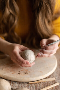 Handcrafting clay egg in studio