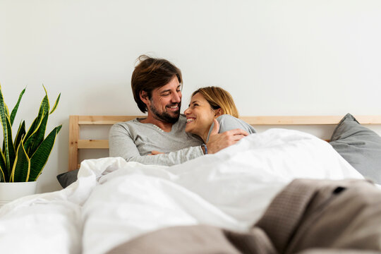 couple relaxing and cuddling on bed