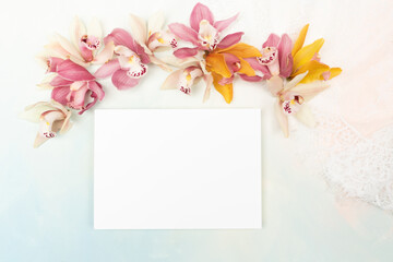 Blank invitation card with copy space and fresh orchids