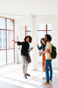 Black real estate agent answering question of man and woman