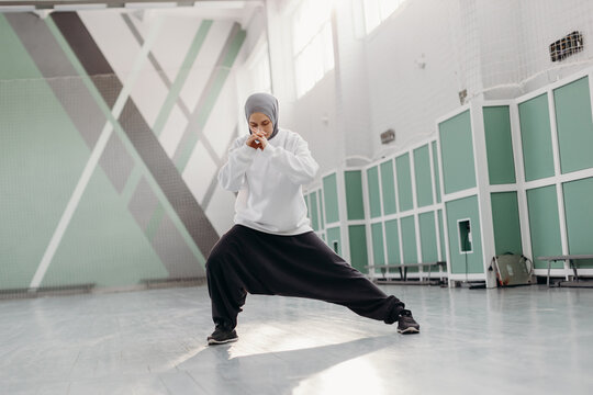 Muslim sportswoman doing side lunge during training