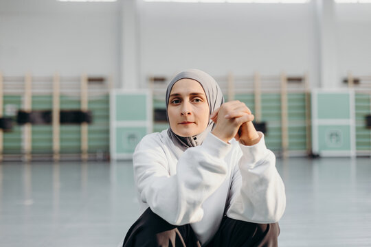 Muslim sportswoman sitting in modern gym and looking at camera