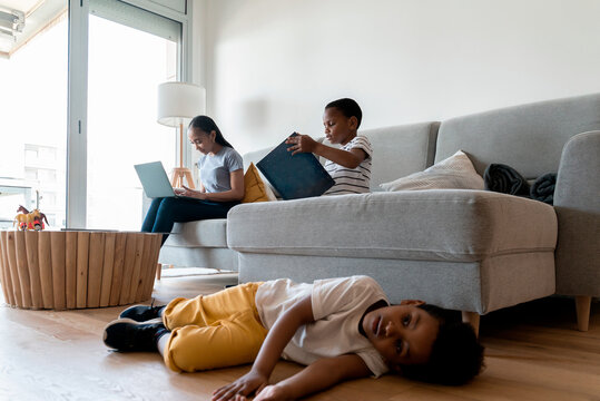 Kids playing at home while their mother works from home