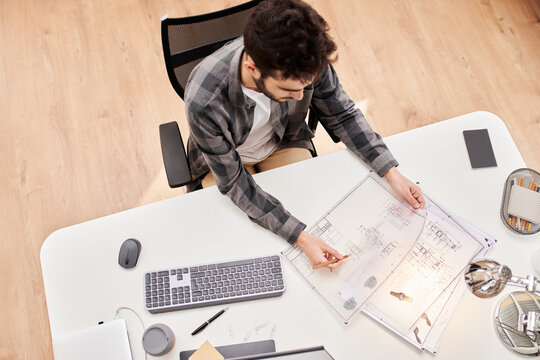 Modern architect with paper drafts at desk