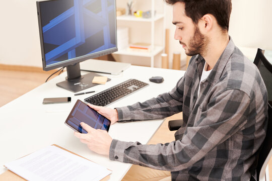 Focused man working with tablet at workplace
