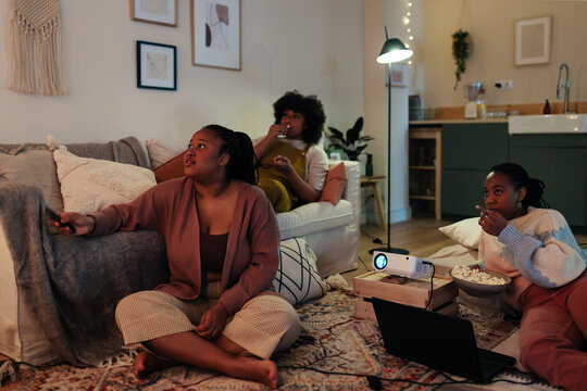 Black girlfriends watching interesting movie at home